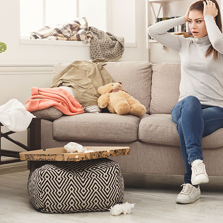 Woman overwhelmed by messy living room