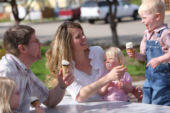 Family having ice cream cones together at park