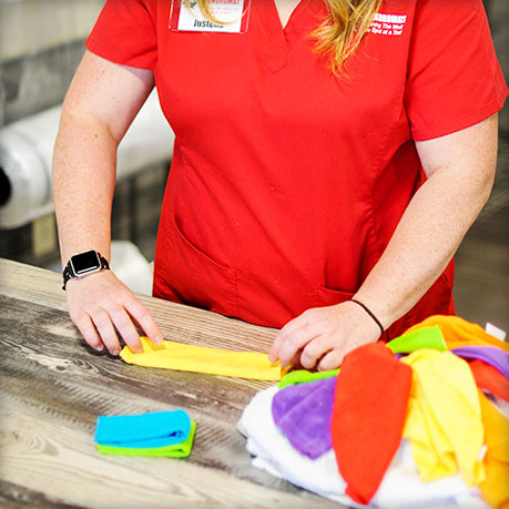 Spot laundry attendant folding laundry wash and fold laundry service