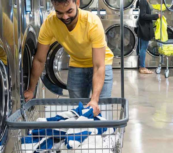 Spot Laundromat Camp Hill, Pa Man putting towels into a washer