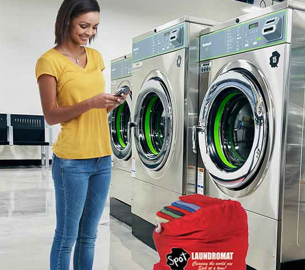 Happy woman on a cell phone pickup up her laundry at the Ranson, WV Spot Laundromat