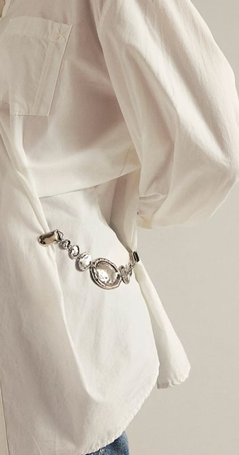 concho brooch worn as a cinch on the back of a white shirt